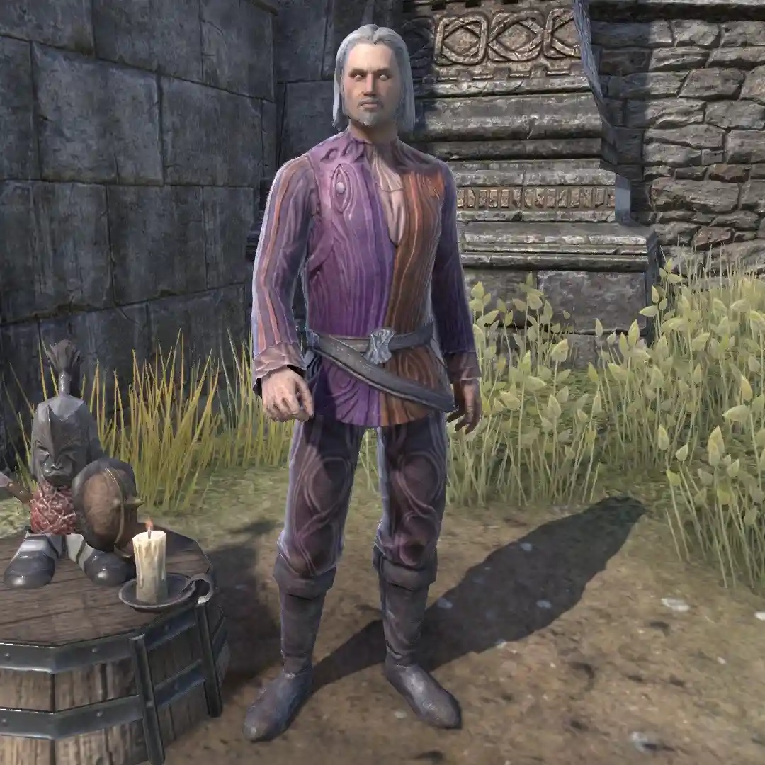 A video game character with gray hair and a purple and brown outfit stands beside a table with a candle and a small statue…