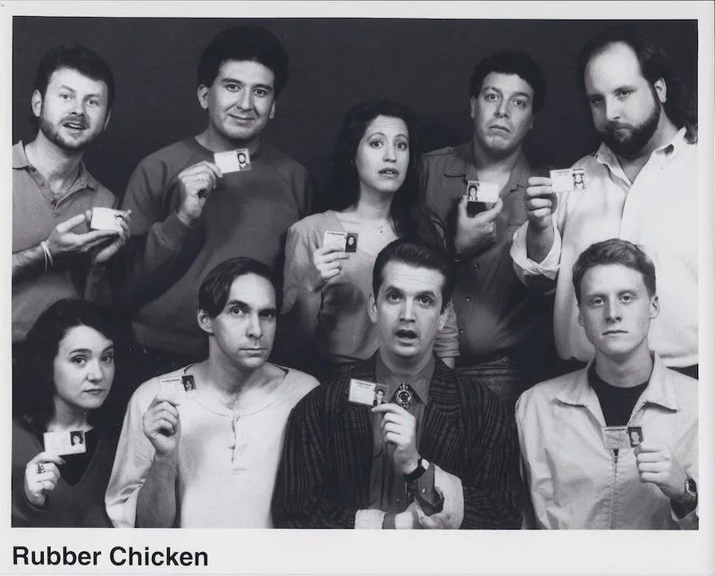 A black-and-white group photo of the cast of 'The Office' (U.S. version) holding up small ID badges with their photos on…