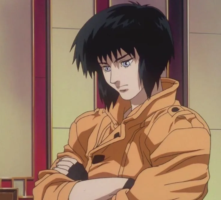 An anime character with short black hair and blue eyes, wearing an orange jacket, stands with arms crossed in a room with…