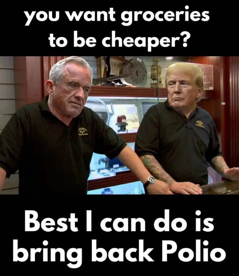 Two men in black polo shirts stand at a counter in what looks like a museum or display case. The man on the left, with gray…