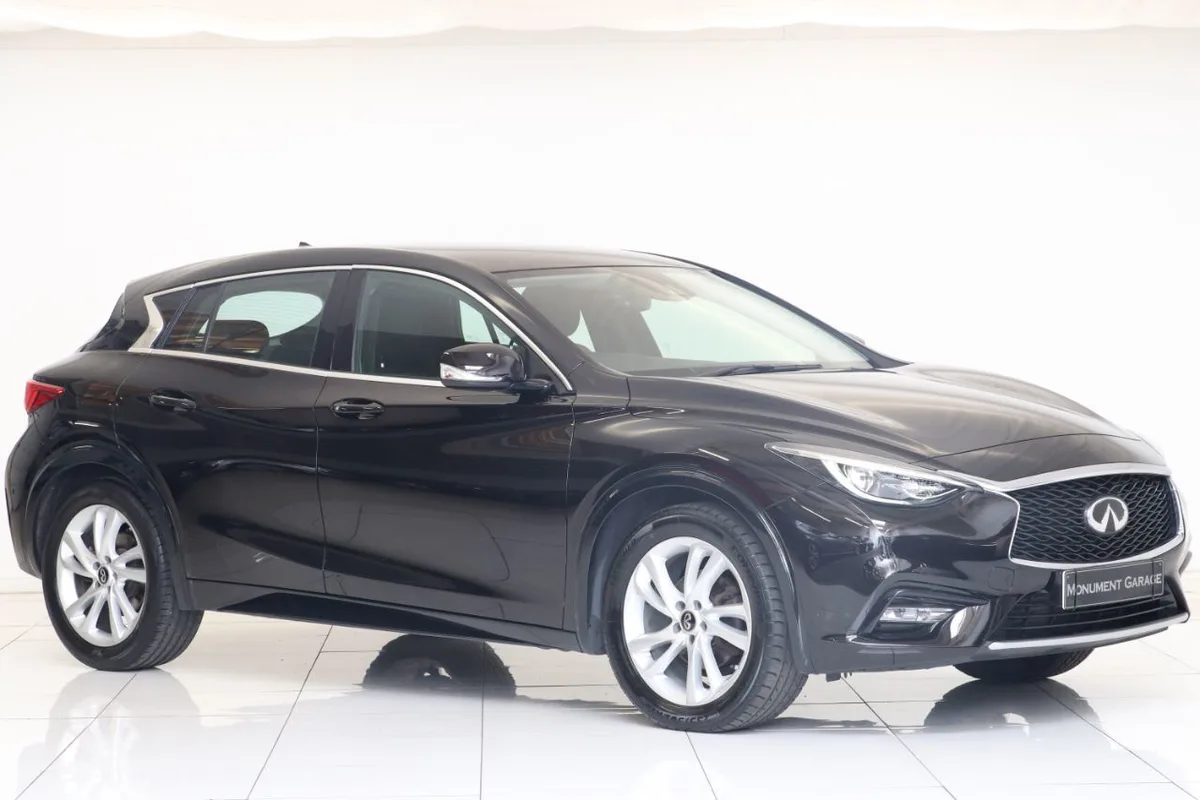 A glossy black Infiniti Q30 SUV is photographed in profile against a stark white studio background with reflective white…