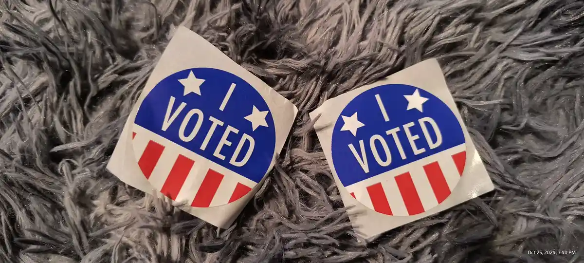 Two identical 'I VOTED' stickers with a patriotic design featuring a blue circle with white stars and red and white stripes…