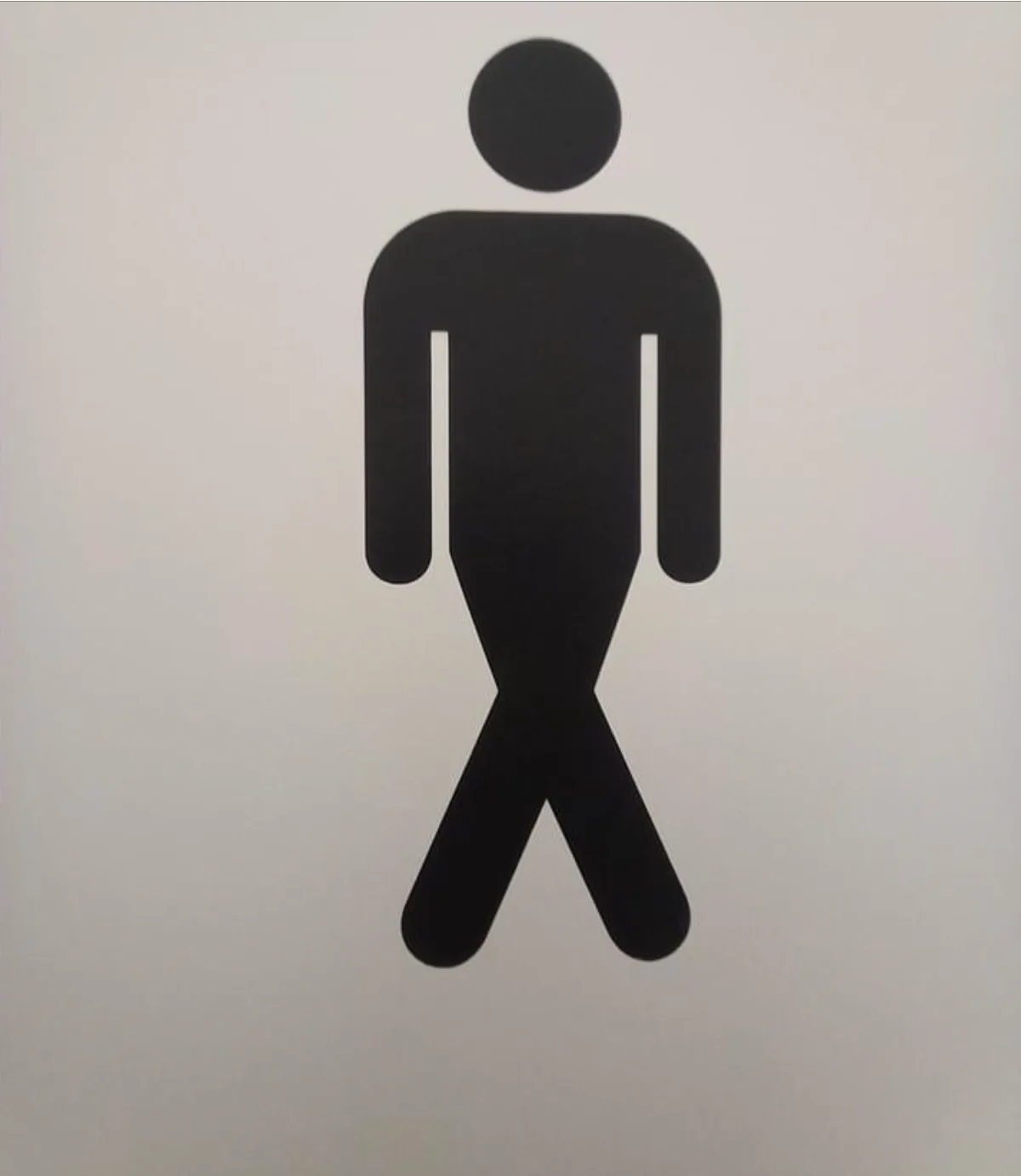 a black male restroom symbol on a white background, but the legs are crossed, implying the person is sitting or has a…