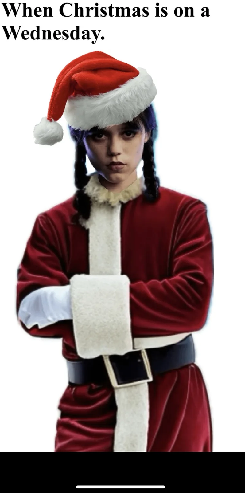 A person with dark hair in braids, wearing a red velvet Santa suit with white trim and a matching Santa hat, stands with…
