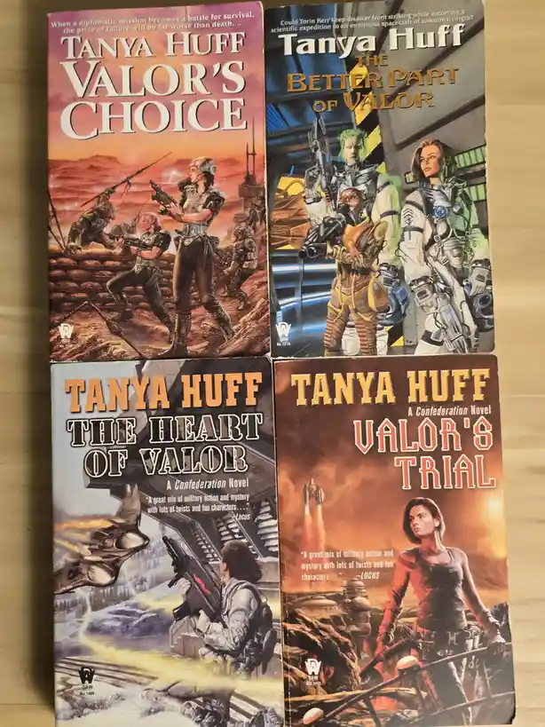 Four paperback books by Tanya Huff are arranged in a grid, all part of the 'Valor' series. The covers show science fiction…