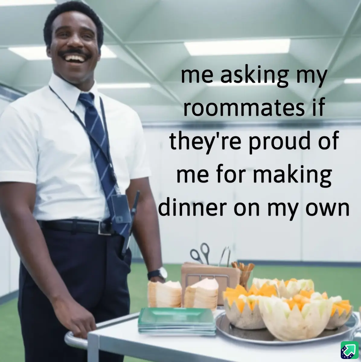 A man in a white shirt and tie, smiling broadly while pushing a cart with food trays, including carved melons and plates…