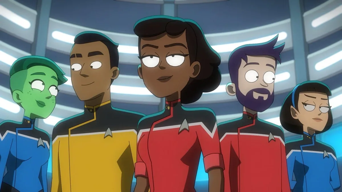 Five animated Starfleet crew members from 'Star Trek: Lower Decks' stand in a row, wearing their colored uniforms. The…