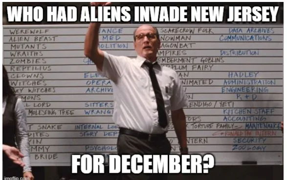 A man in a white shirt and tie stands in front of a whiteboard filled with handwritten lists of fictional creatures and…