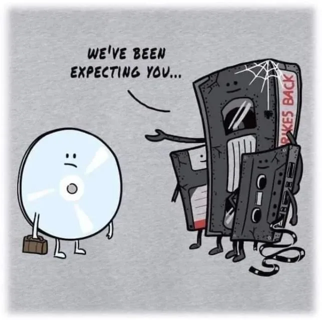 A cartoon CD with a briefcase stands facing a group of anthropomorphic, dusty, and broken vintage media formats — a VHS…