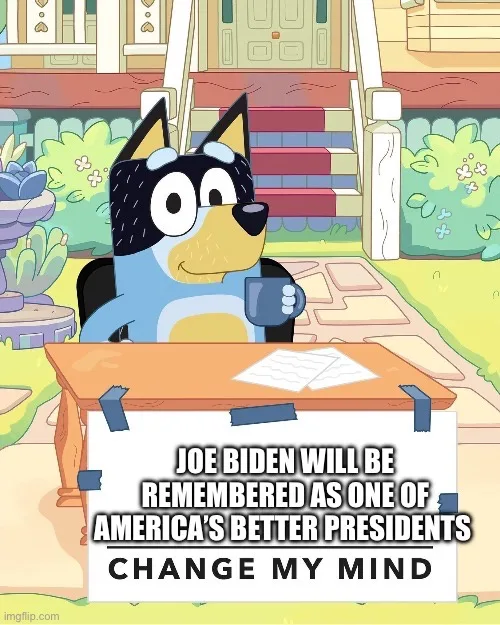 A cartoon blue heeler dog, Bluey, sits at a wooden desk outdoors holding a mug, with a whiteboard taped to the desk…