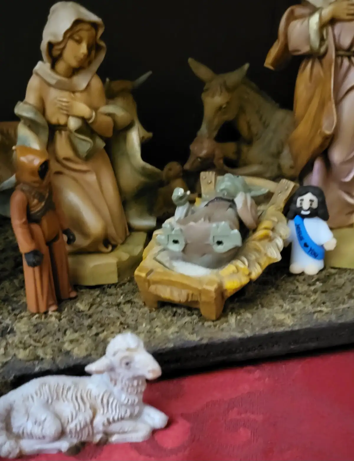 A nativity scene figurine set includes traditional figures like Mary, Joseph, animals, and a baby Jesus in a manger, but is…