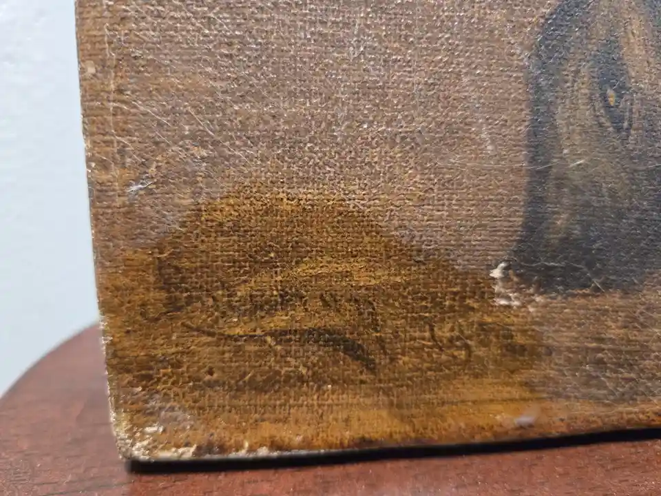 A close-up of a heavily worn, brown leather-bound book cover with visible scratches, scuffs, and a faded, smudged face-like…