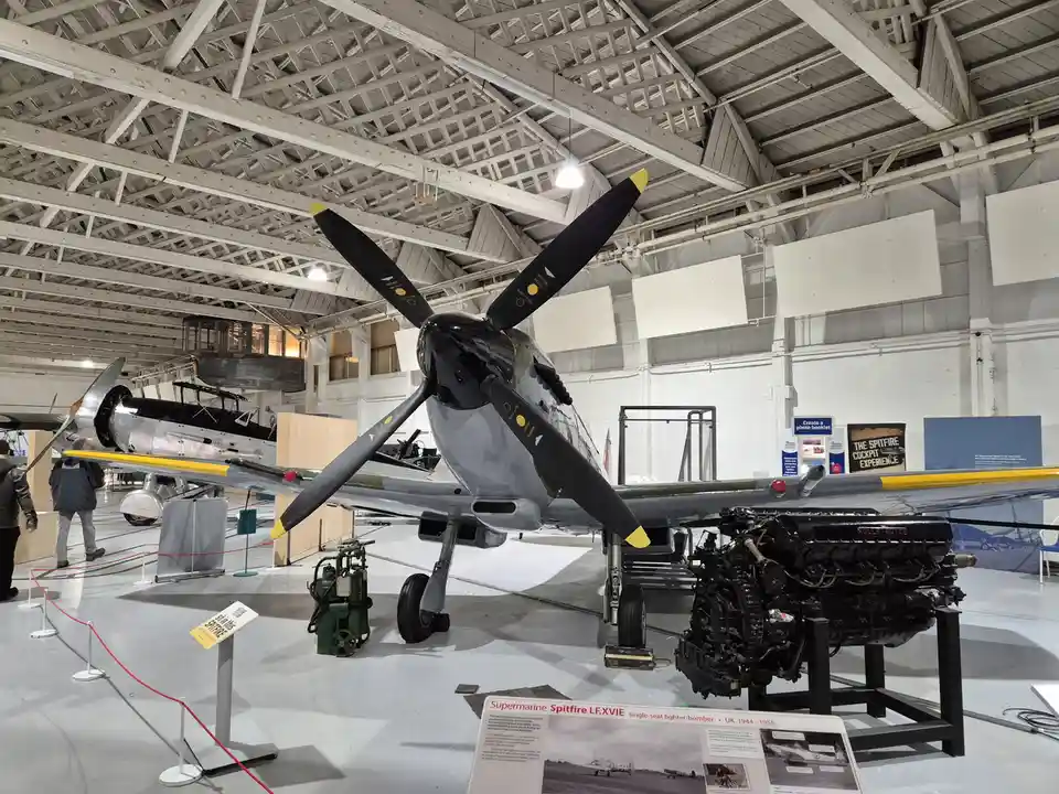A preserved Supermarine Spitfire LF.XVIE fighter-bomber is displayed in an aviation museum, with its engine removed and…