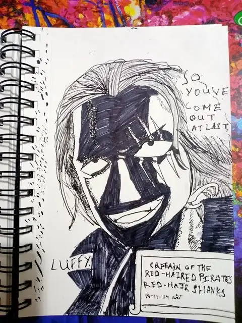 A hand-drawn sketch in a spiral-bound notebook depicts a stylized, half-masked anime character with wild hair and a wide…