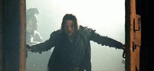 a still image from 'The Matrix' shows keanu reeves as neo standing in a doorway with arms outstretched, holding two pistols…