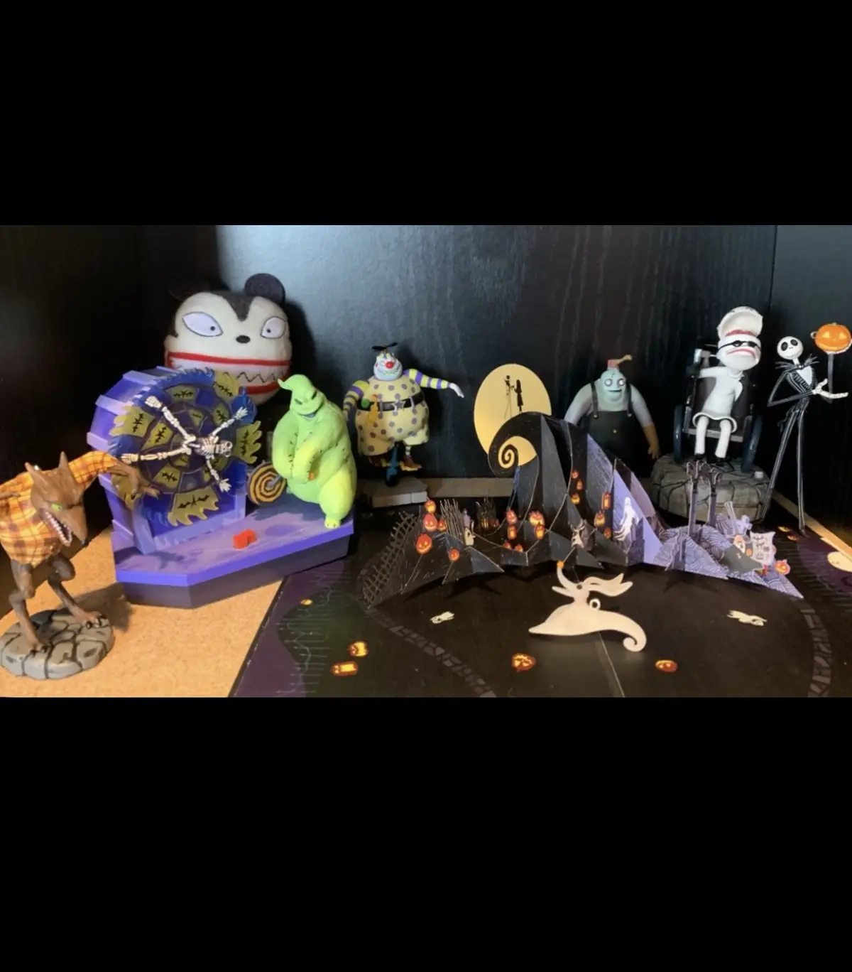 A collection of 'The Nightmare Before Christmas' figurines and dioramas, including Jack Skellington, Sally, Zero, Oogie…