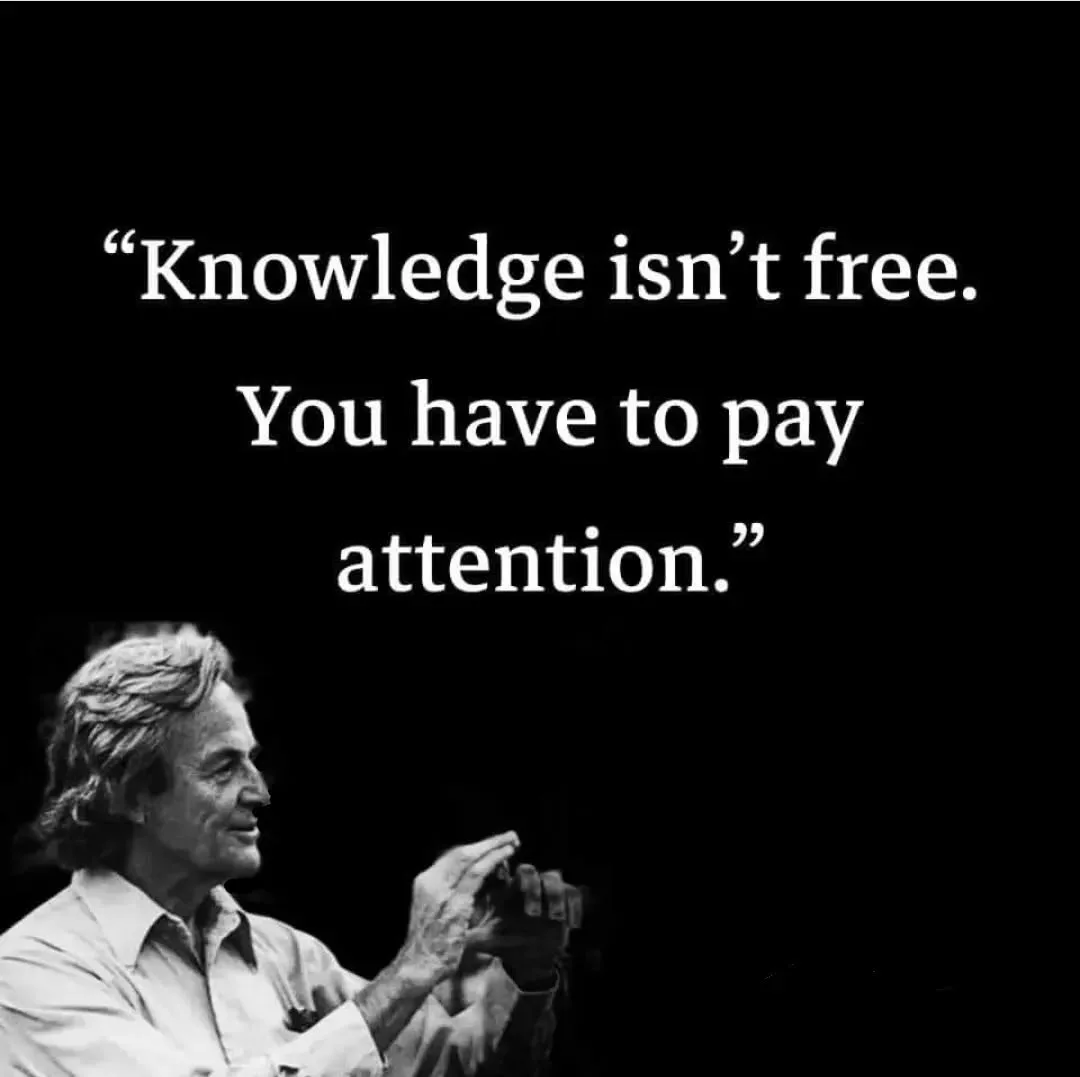 A black-and-white photo shows an older man with wavy hair, wearing a collared shirt, gesturing with his hands as if…