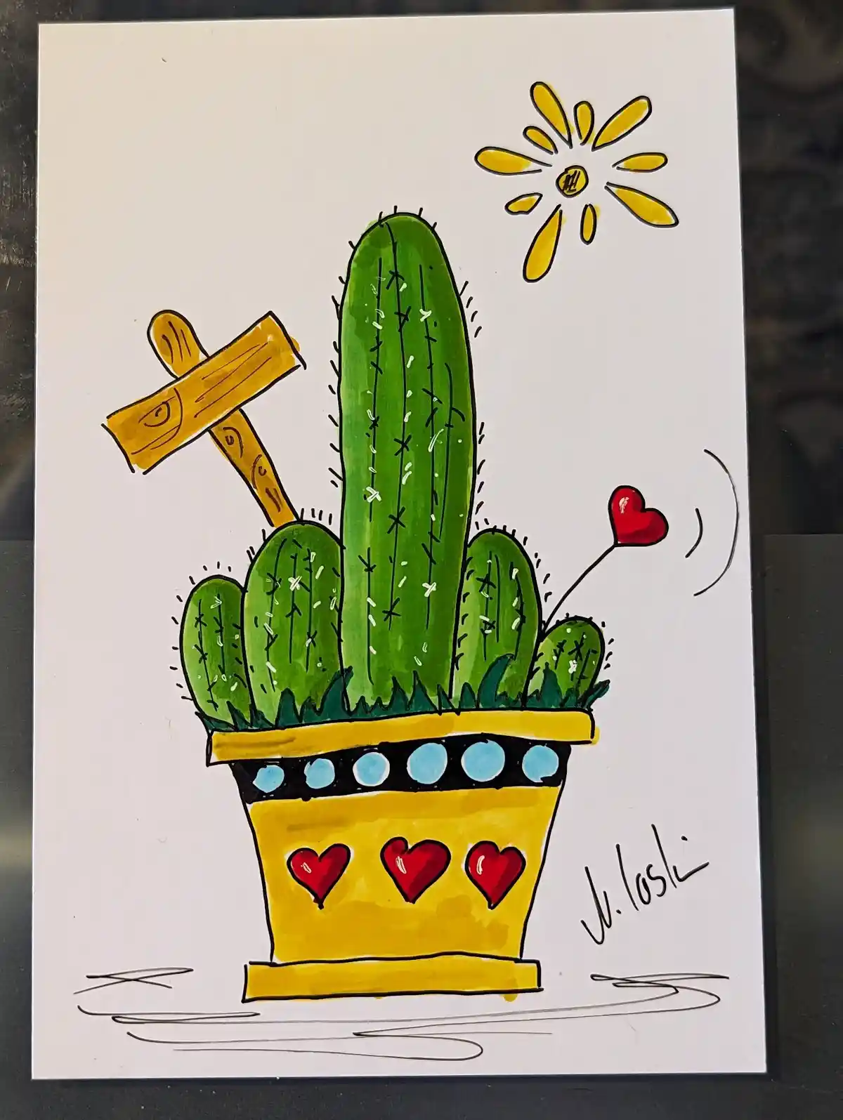 A hand-drawn cartoon illustration shows a green potted cactus with a wooden hammer stuck into its side, a red heart floating…