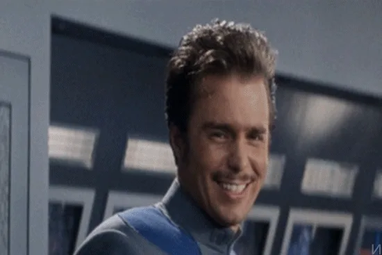 A man in a blue uniform smiles broadly while looking at a glowing green heart icon overlaid on a screen interface, then…
