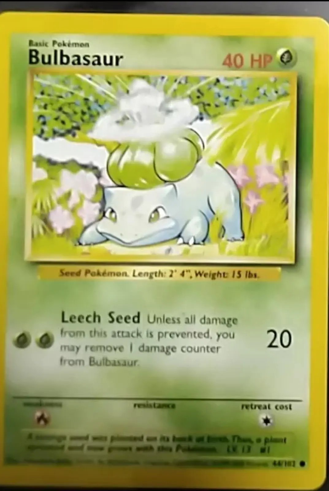 A Pokémon trading card featuring Bulbasaur, a small green and white creature with a plant growing on its back, set against a…