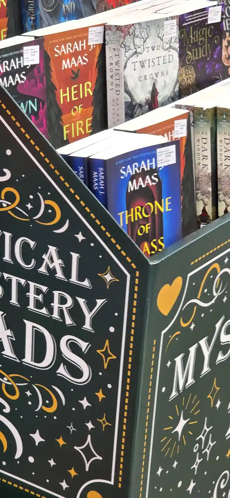A bookstore display labeled 'Magical Mystery Reads' features books by Sarah J. Maas, including 'Heir of Fire' and 'Two…