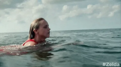 A six-panel image sequence shows a woman in a red swimsuit swimming in the ocean, transitioning from looking forward to…