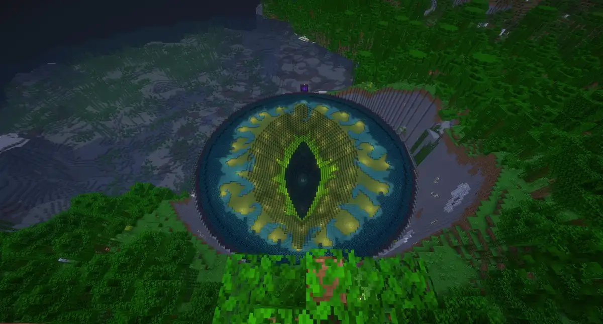 An aerial view of a massive, pixelated eye constructed in Minecraft, surrounded by dense green forests and grey terrain. The…