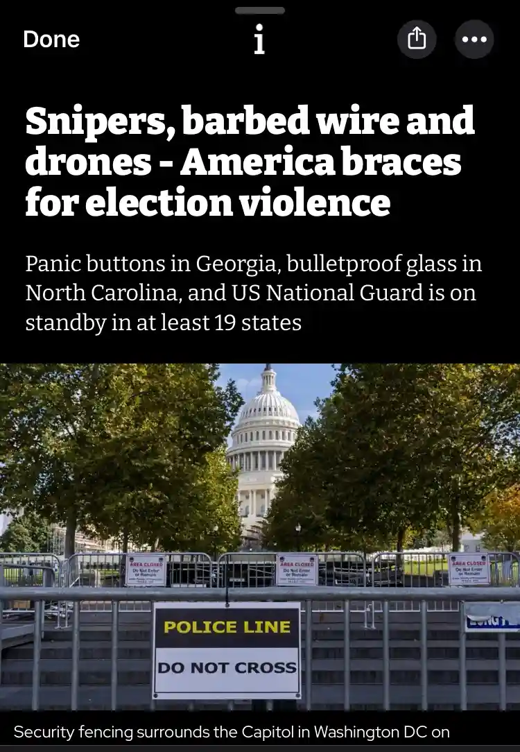 The image shows the U.S. Capitol Building partially obscured by trees, with metal security fencing and 'POLICE LINE DO NOT…