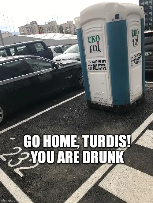 A blue and white portable toilet branded 'EKO TOI' is parked in a marked parking space in a lot with cars. Large white text…