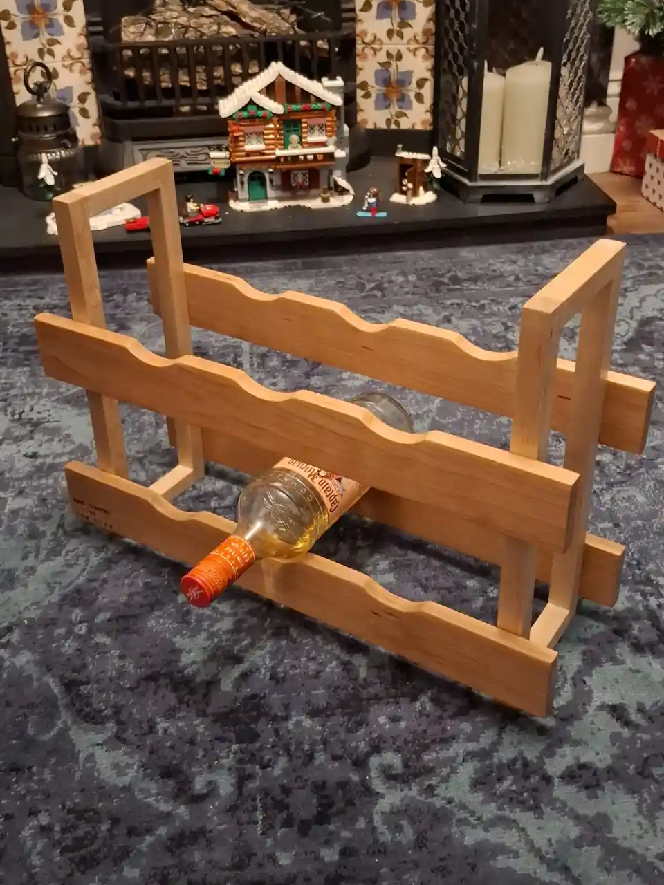 A wooden wine rack, designed to hold bottles horizontally, is shown with only one bottle of Captain Morgan rum partially…
