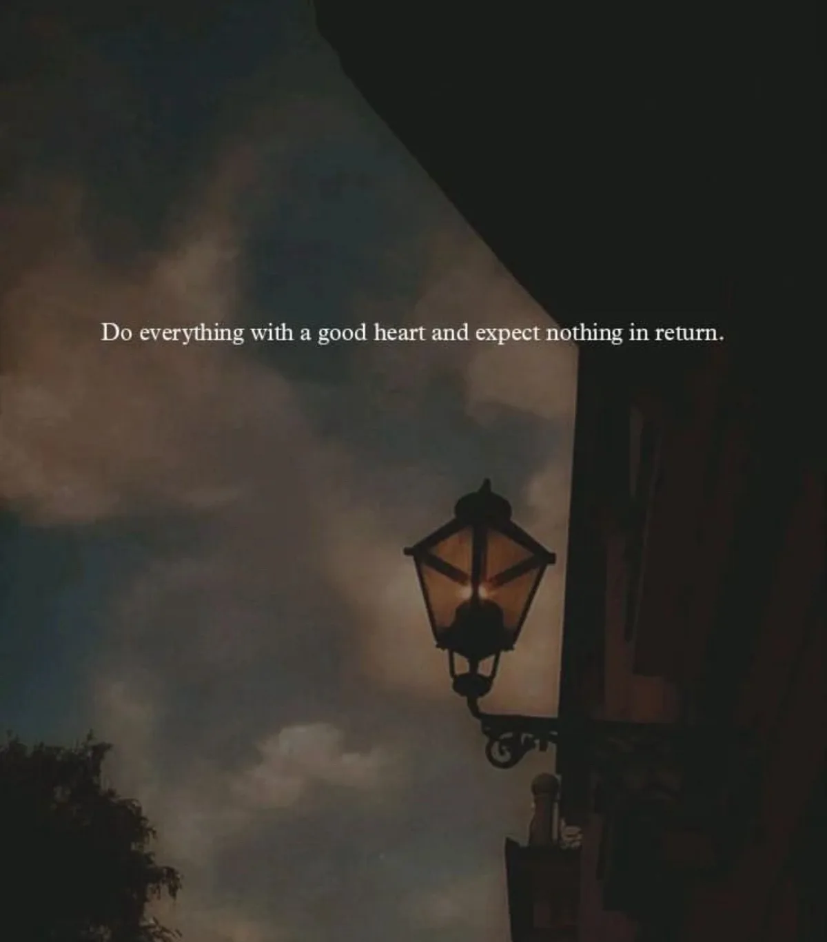 A dimly lit, vintage-style street lamp is mounted on a dark building against a moody, cloudy sky. White text overlaid on the…