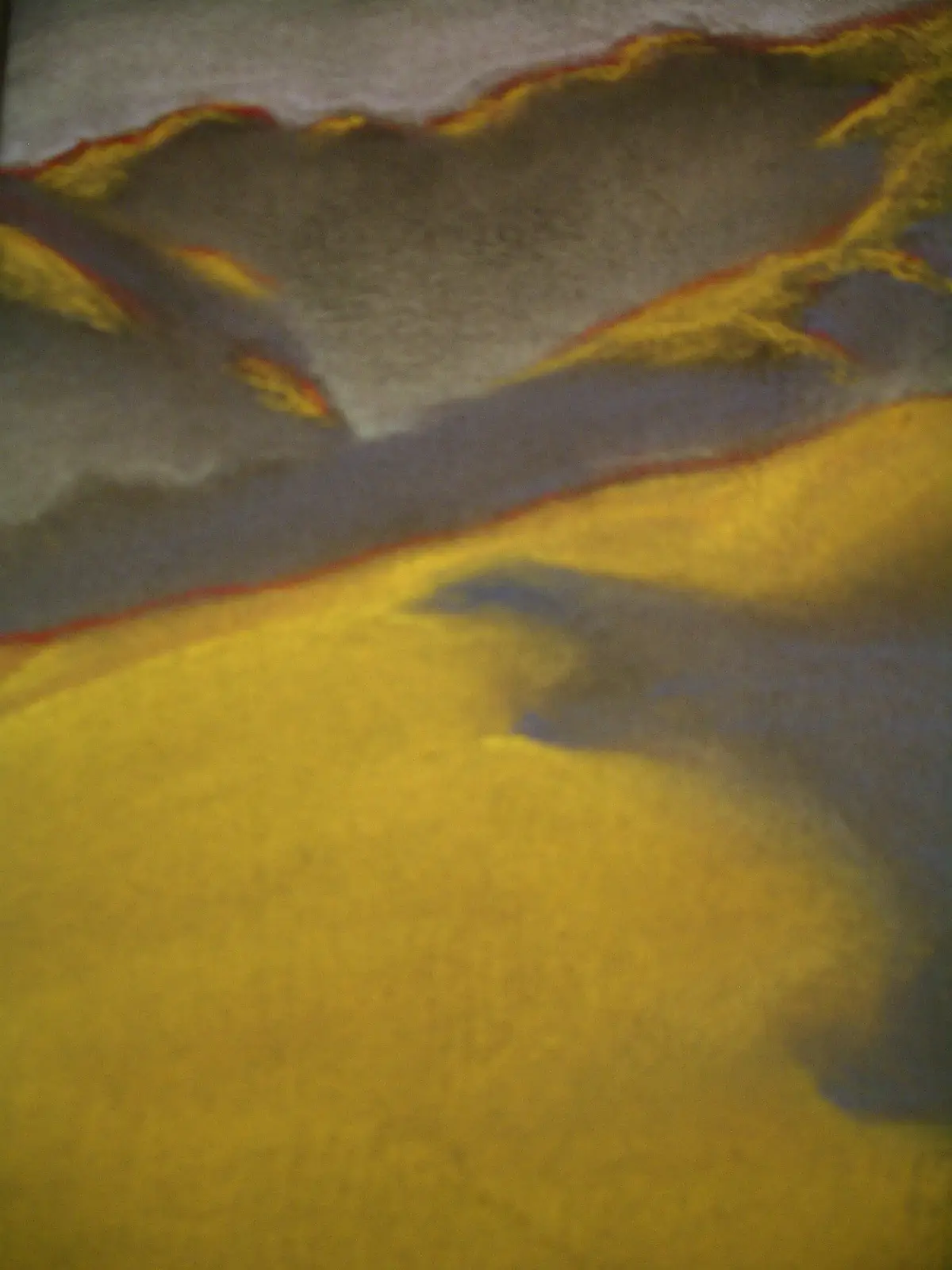 A blurry, abstract image of a textured surface with layered colors—yellow, gray, and red—resembling a painting or fabric…