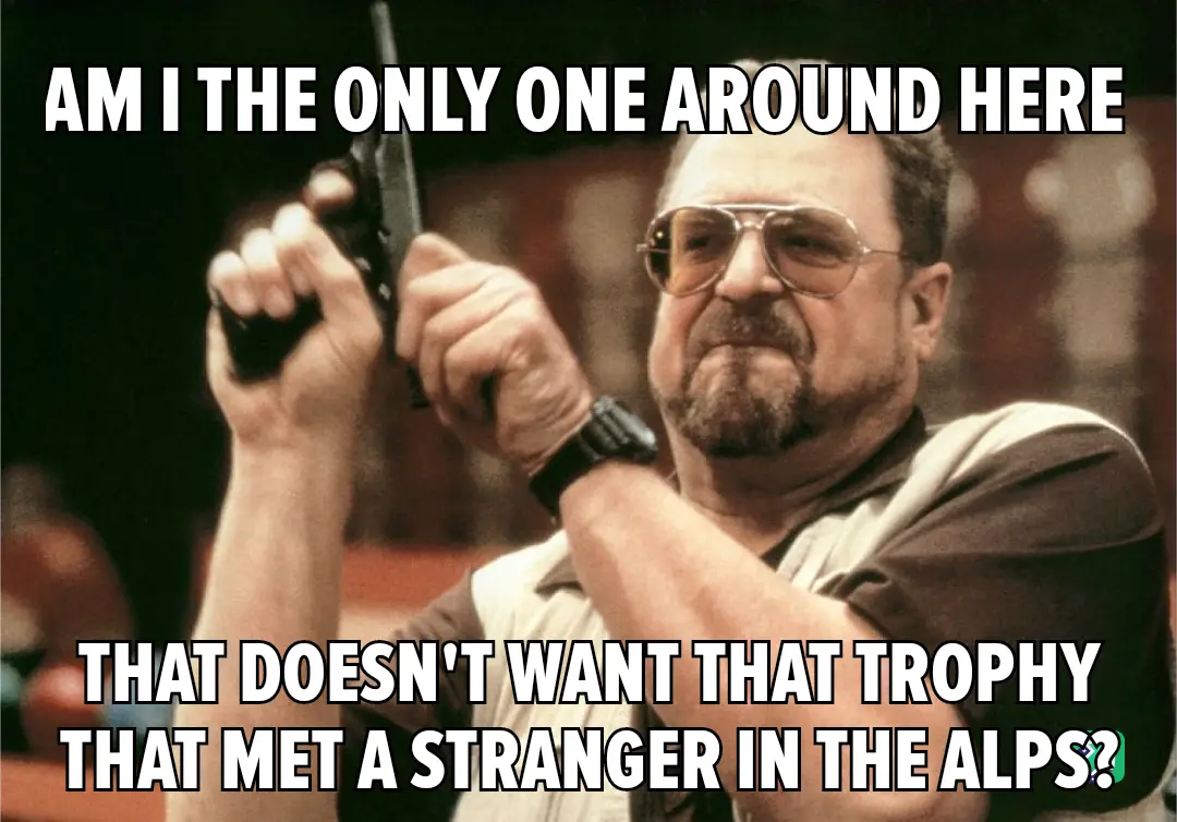 A man with aviator sunglasses and a goatee holds a handgun with both hands, looking intensely at the viewer. The image has…