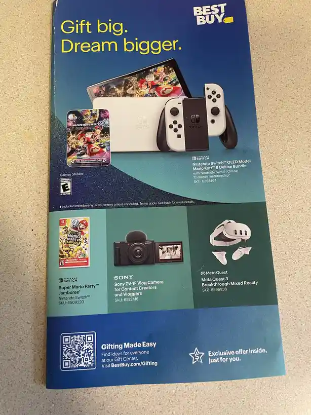 A Best Buy promotional flyer showcasing gaming and tech products including a Nintendo Switch OLED with Mario Kart 8 Deluxe…