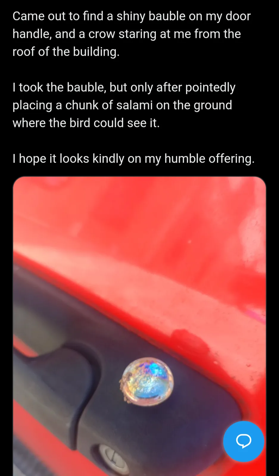 A close-up photo shows a small, iridescent, bubble-like bauble resting on a black door handle of a red vehicle. Overlaid…