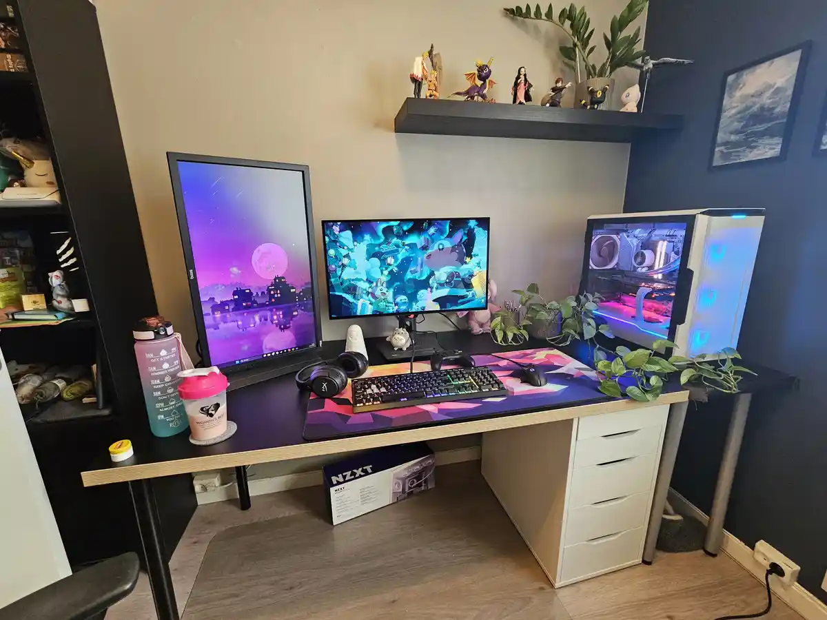 A well-organized gaming desk features two monitors, a glowing white PC case, a keyboard, mouse, and headphones. The desk is…