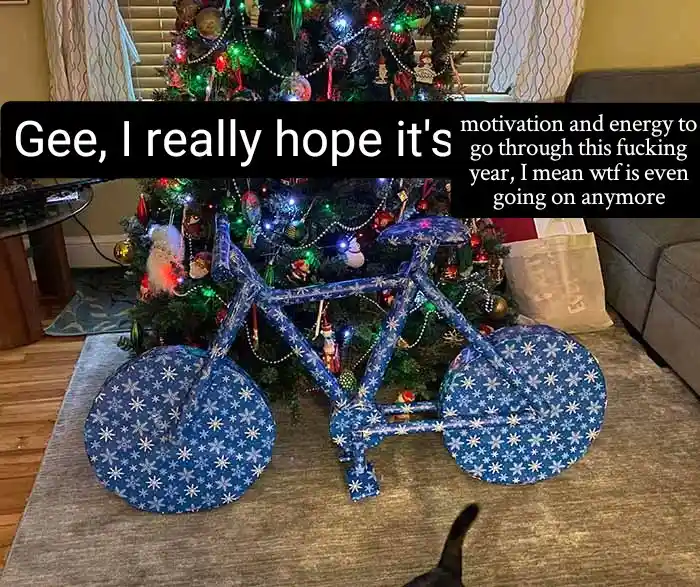 A bicycle, entirely wrapped in blue Christmas wrapping paper with white snowflake patterns, is positioned in front of a…