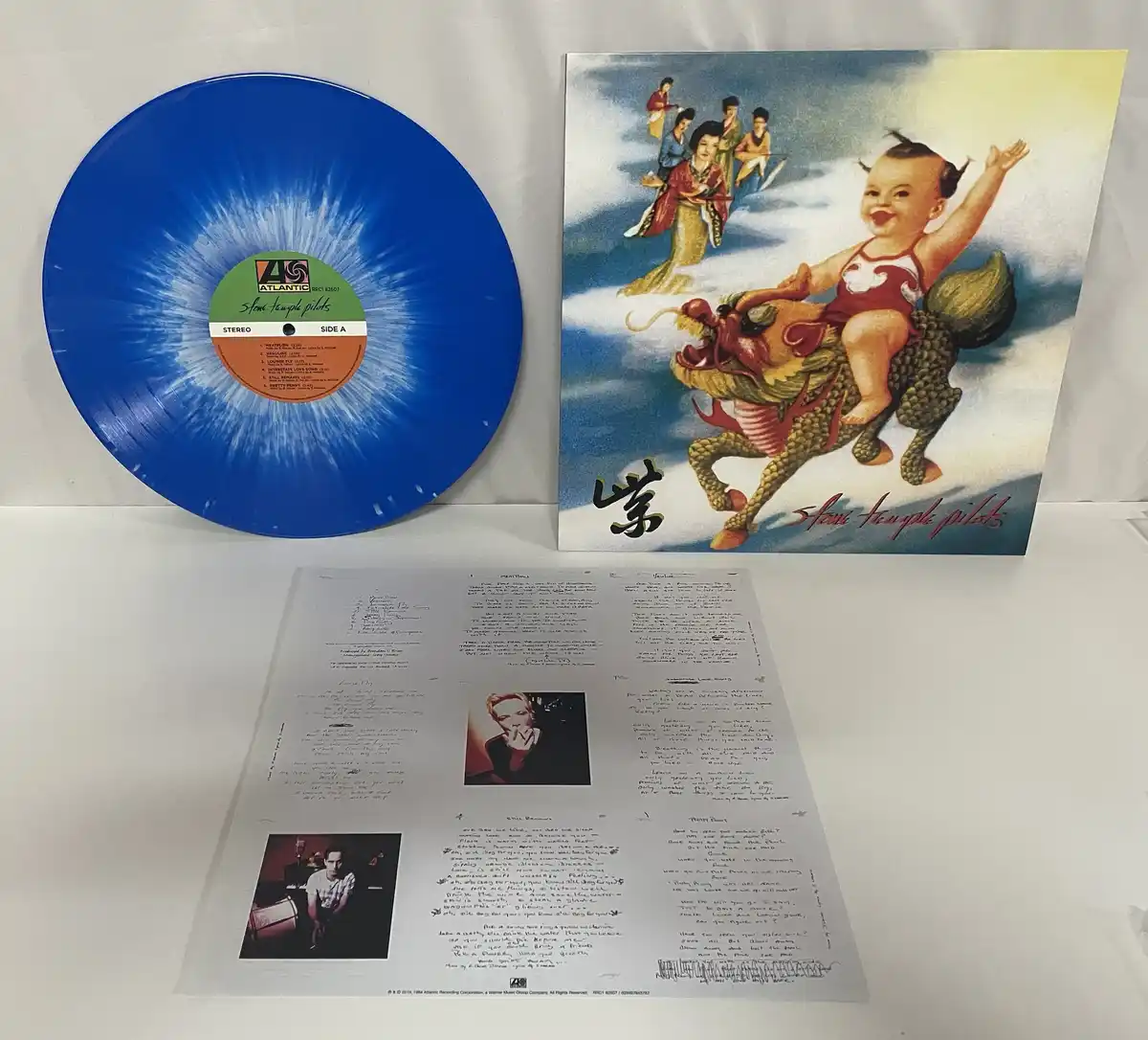 A blue vinyl record and its album cover for Stone Temple Pilots' 'Purple' are displayed next to the handwritten lyrics…