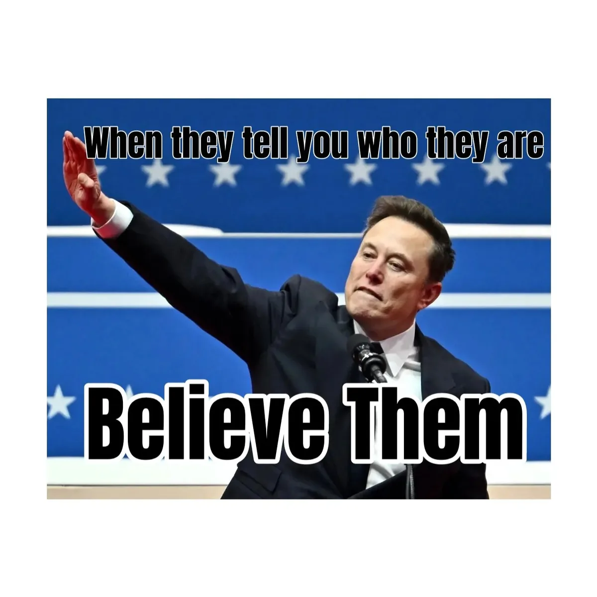 A man in a dark suit stands at a podium with a microphone, raising his right hand in a gesture of affirmation or oath…
