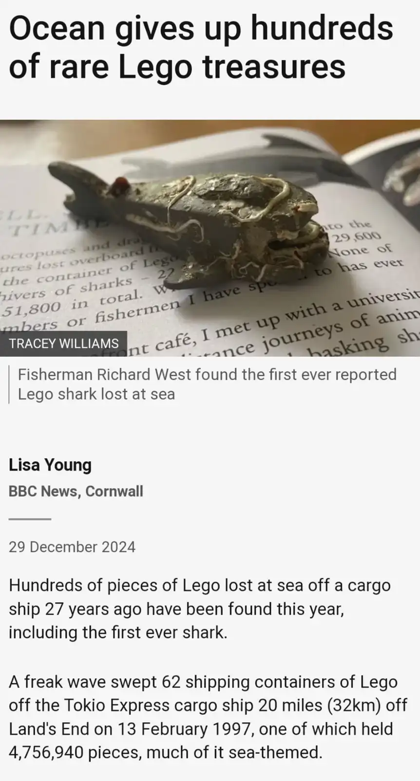 A weathered, sea-encrusted Lego shark is displayed on an open book, overlaid with a fake news article headline claiming the…