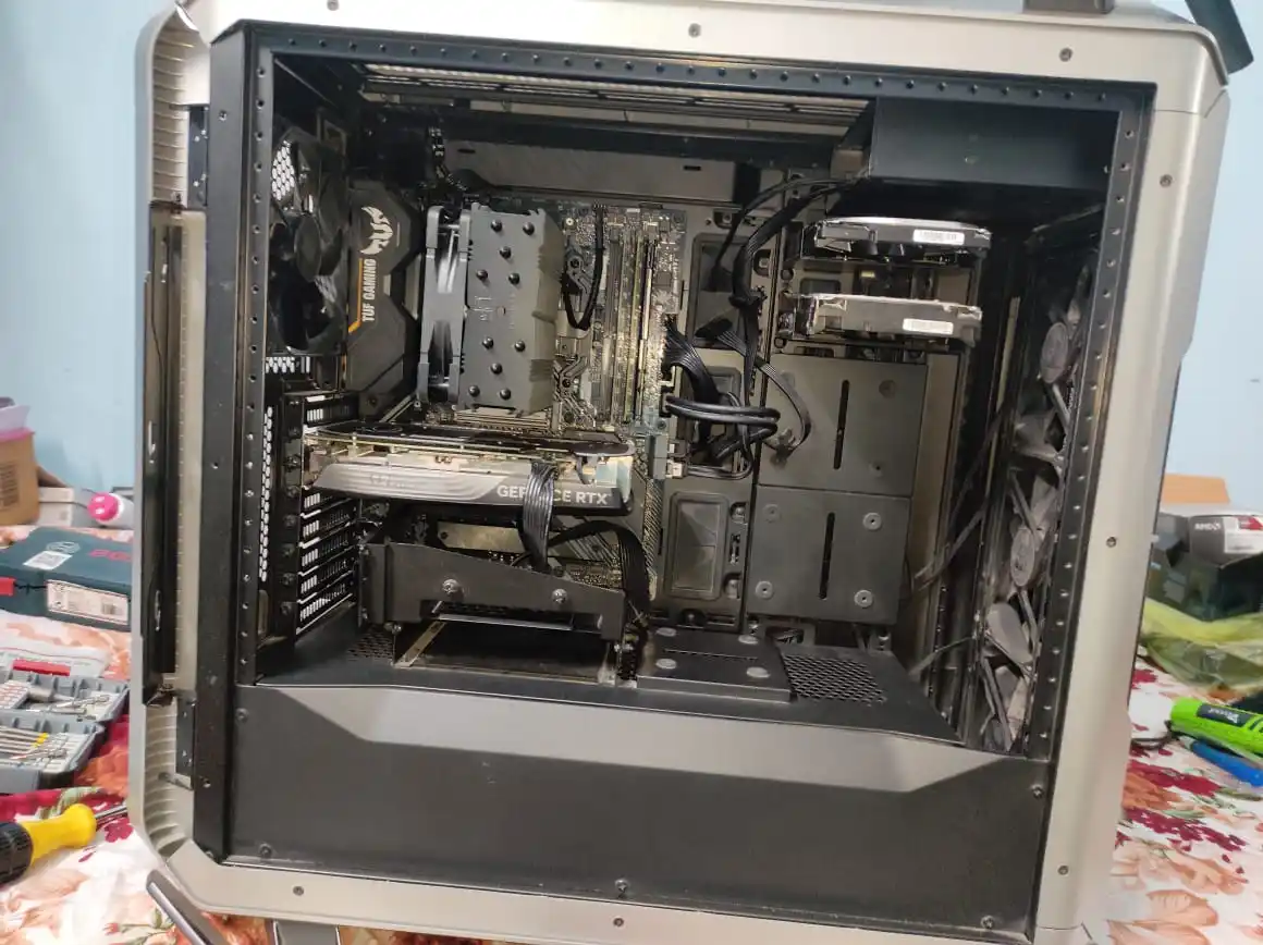 A photo of an open computer case showing internal components like a TUF Gaming CPU cooler, a GeForce RTX graphics card, and…