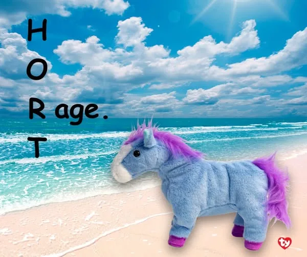 A blue plush horse with a purple mane and tail stands on a sandy beach with ocean waves and a bright blue sky with clouds…