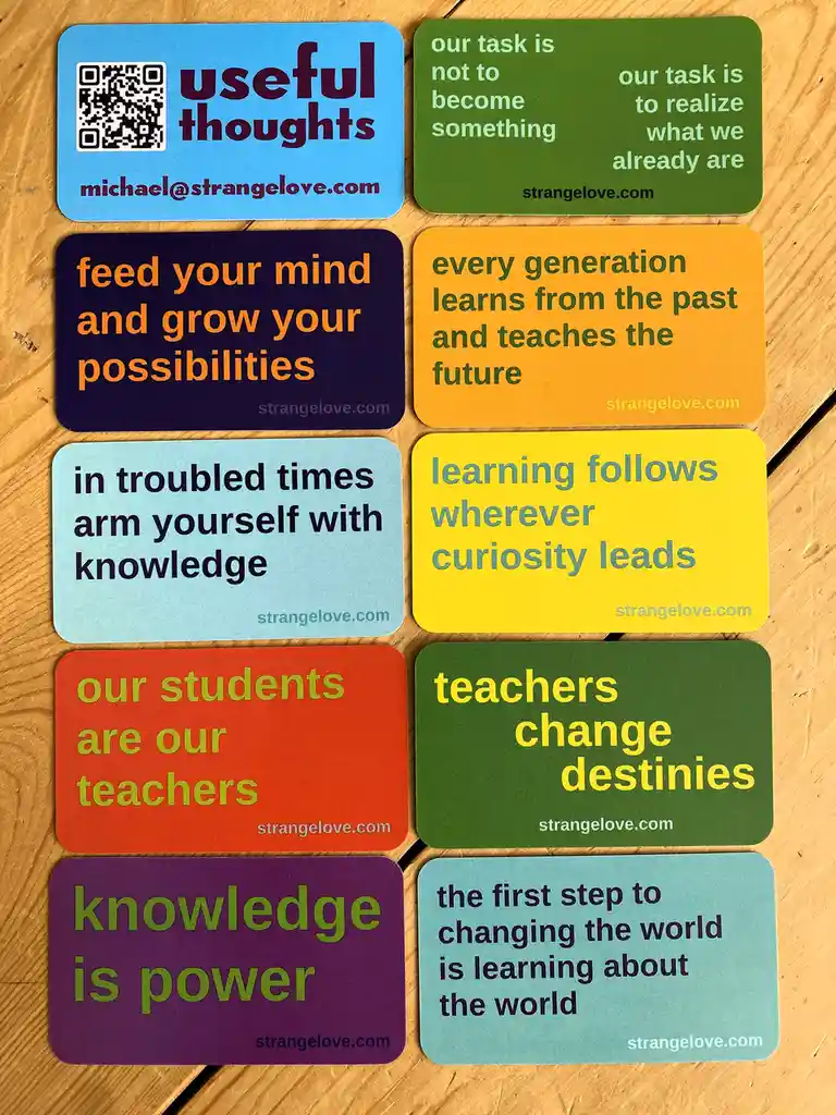 Eight colorful rectangular cards arranged on a wooden surface, each displaying a different inspirational quote about…