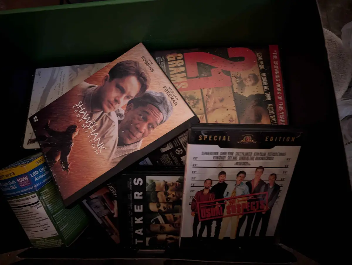 A cluttered box contains several DVD cases, including 'The Shawshank Redemption', 'Grim's Grimm', 'Takers', and 'Usual…
