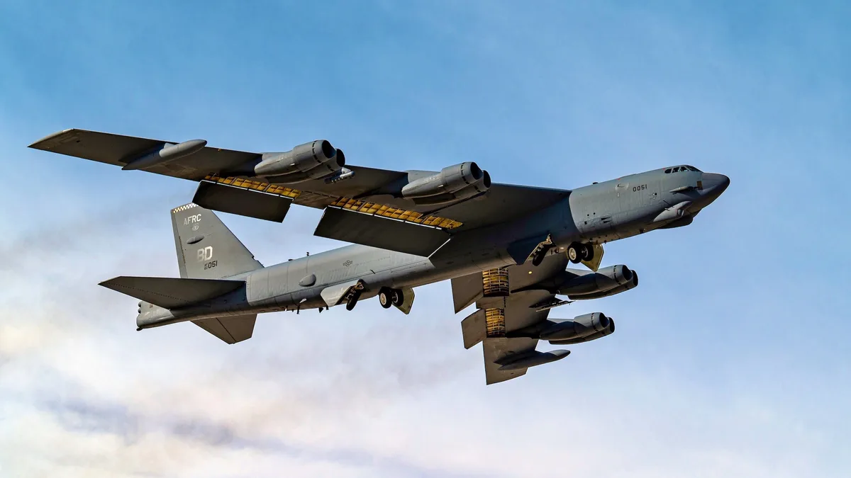 A large, gray military bomber aircraft, identified as a B-52 Stratofortress by its distinctive eight-engine configuration…