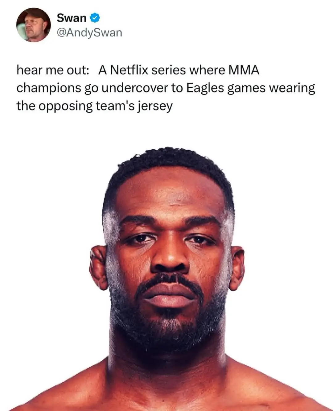 The image shows a close-up of a shirtless Black man with a serious, deadpan expression, looking directly at the camera…