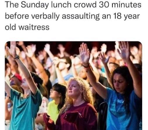 A photo of a crowd of people, mostly young adults, with their hands raised in the air as if in worship or prayer. The image…