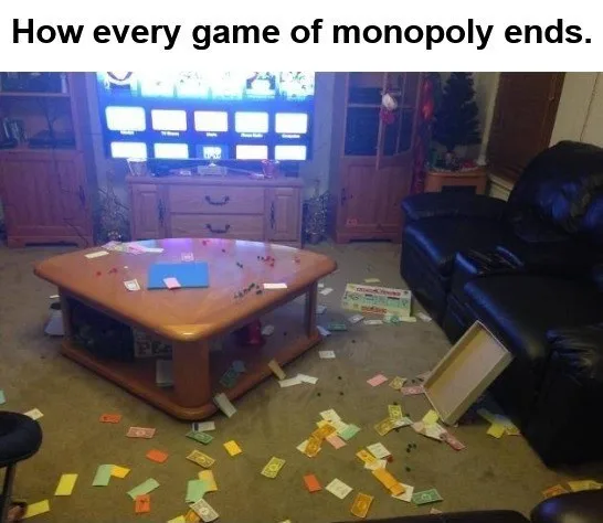 A messy living room with a wooden coffee table covered in Monopoly game pieces and a blue board. Monopoly money is scattered…