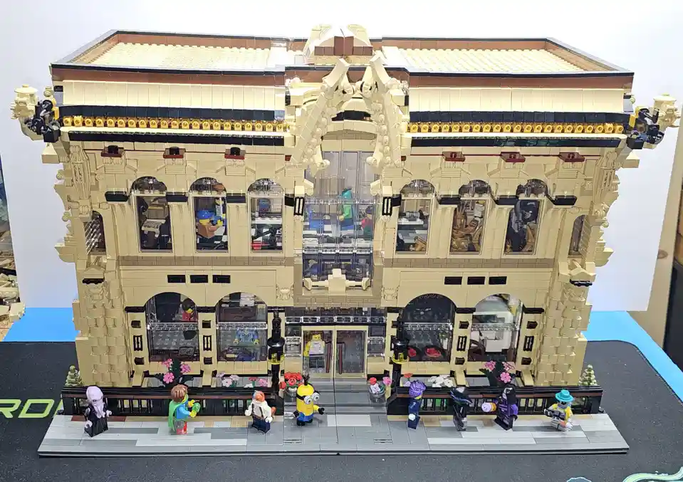 A highly detailed LEGO model of an ornate, multi-story building with arched windows and intricate facade, featuring numerous…