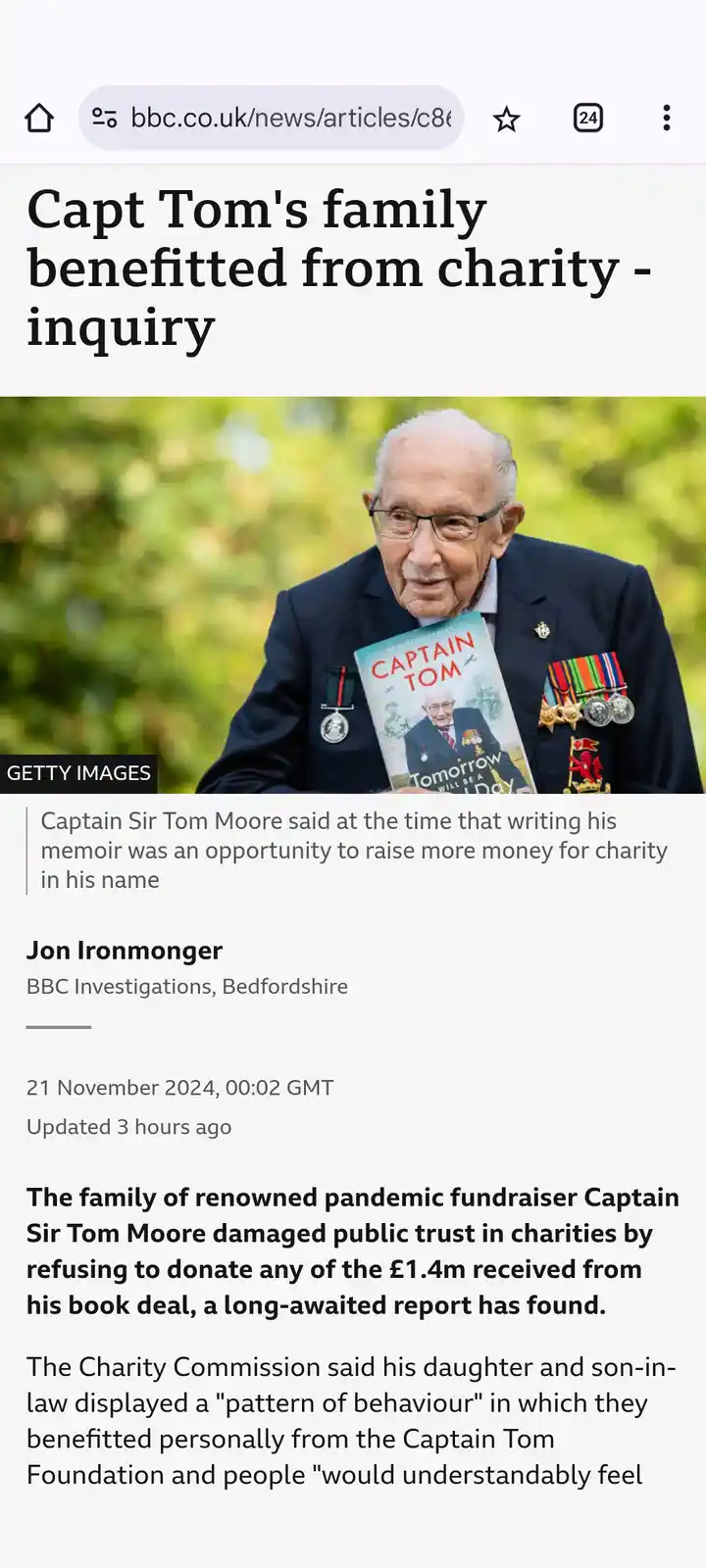 A screenshot of a BBC news article about Captain Sir Tom Moore, showing a photo of him holding his autobiography. The…